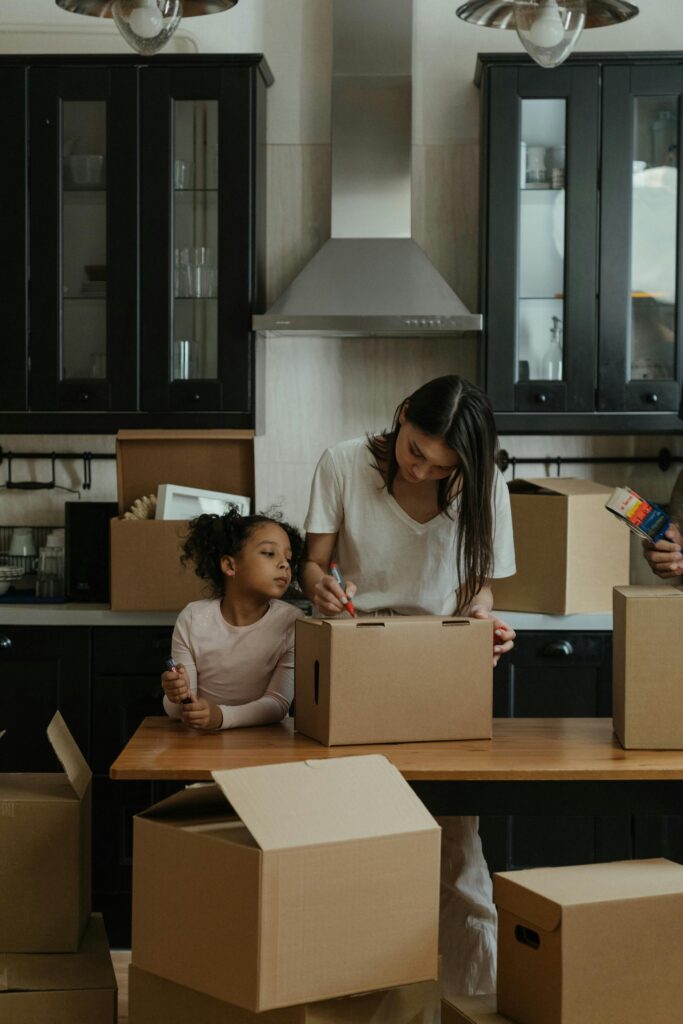 A family packs up items from their kitchen cabinets before painting the cabinets